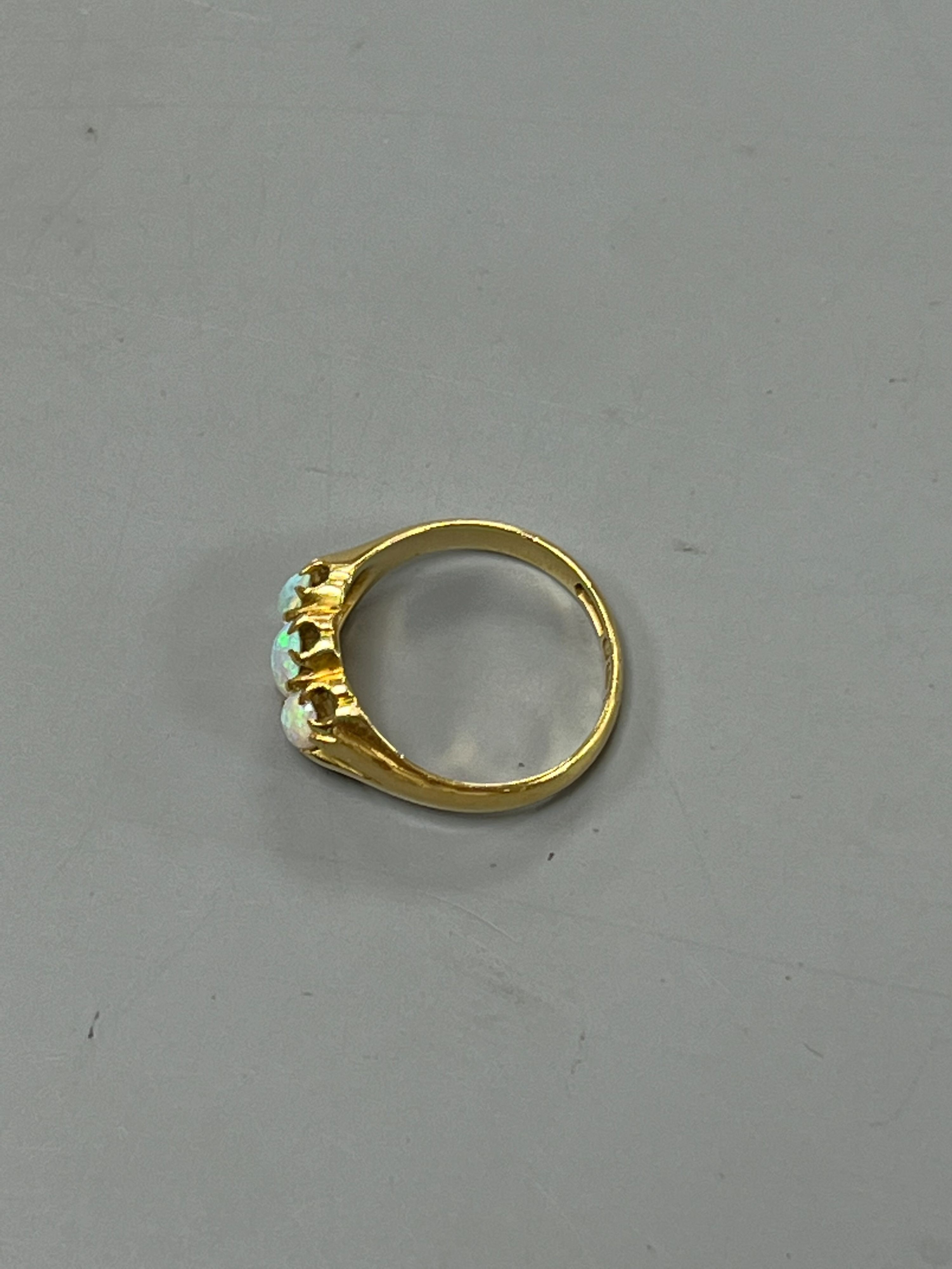 A late Victorian 18ct gold and claw set three stone white opal ring, size M, gross weight 4.1 grams.